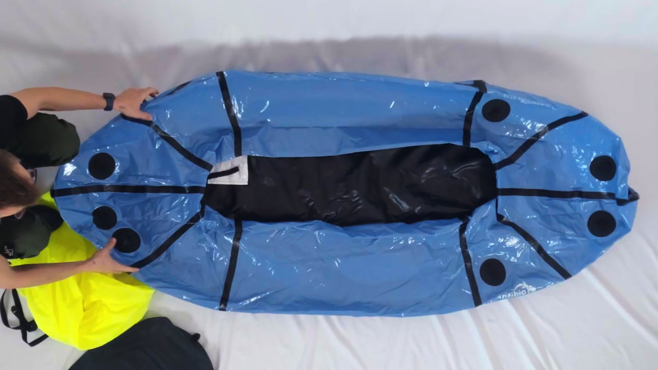 Packraft gjøres klar til oppblåsing med pumpesekk — stillbilde fra Anfibios offisielle monteringsvideo