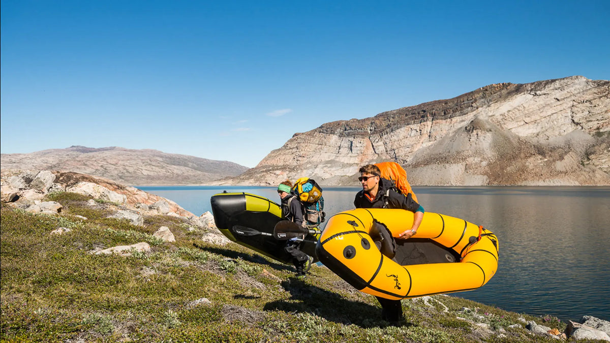 To padlere bærer oppblåste Anfibio Sigma TX packrafts langs kanten av et fjellvann. Foto: Anfibio