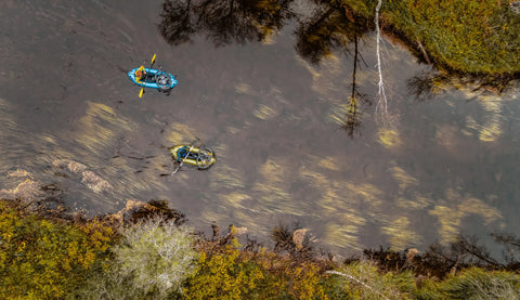 To Anfibio Delta MX packrafts med sykler på dekk padler ned en finsk elv. Viser packraftens enorme lastekapasitet for bikerafting-ekspedisjoner. Foto: Sven Schellin.