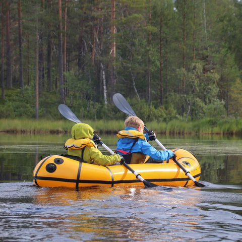 To barn padler sammen i en Anfibio Delta MX på en rolig innsjø. En trygg og stabil packraft som egner seg ypperlig for familiebruk. Foto: Sven Schellin.