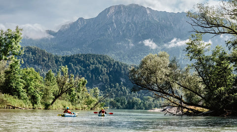 Padling med Anfibio Revo CL på rolig vann med spektakulær utsikt mot Herzogstand-fjellet. En allsidig packraft for både elv og innsjø. Foto: Anfibio Packrafting.