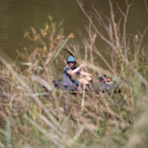 Anfibio Nano RTC manøvreres smidig mellom trær i vannkanten. Viser packraftens kompakte design og lave vekt for teknisk padling. Foto: Alan Klee.