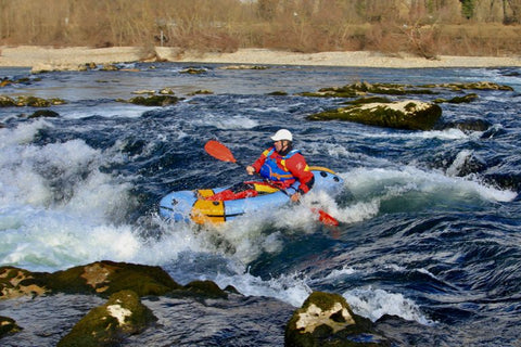 Anfibio Revo CL packraft manøvreres gjennom tekniske elvestryk. Viser spruttrekket og padlerens sentrerte posisjon for maksimal kontroll. Foto: Anfibio Packrafting.