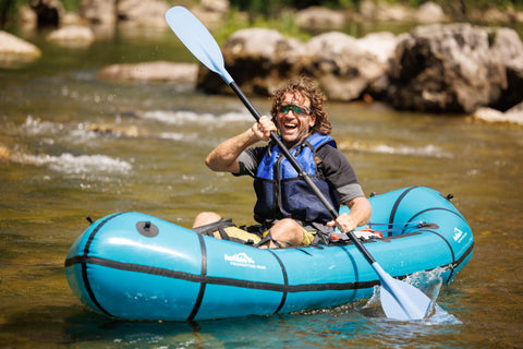 Nærbilde av Gerhard Czerner i en blå Anfibio Sigma TXL+ packraft i en elvestryk. Viser manøvrerbarhet. Foto: Gerhard Czerner.